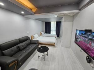 釜山W Residence Hotel Centum City的带沙发、床和电视的客厅