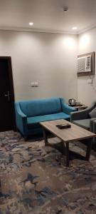 乌姆莱季همم للوحدات السكنيه المخدومة- الدقم的客厅配有蓝色的沙发和茶几