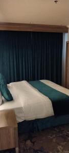 乌姆莱季همم للوحدات السكنيه المخدومة- الدقم的绿窗帘间的一张床位