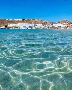 普拉迪斯亚罗斯Acrogiali Beachfront Hotel Mykonos的一片水体,背靠海滩