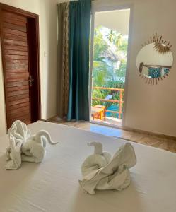 帕杰CeZeRe THE PALM HOTEL的床上的两条毛巾天鹅