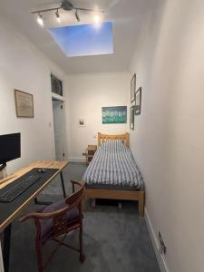 爱丁堡Welcoming Morningside Escape的客房设有一张床、一张桌子和一台电脑