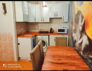 伊斯坦布尔Alpacino Apart Hotel的厨房配有桌子和洗衣机。