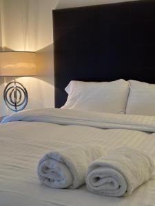 伦敦Canary Wharf Apartments的一间卧室配有带毛巾的床