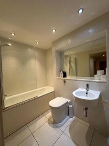 伦敦Canary Wharf Apartments的浴室配有卫生间、盥洗盆和浴缸。