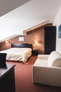 比尔森普尔科米斯特尔酒店的一间卧室配有一张大床和一张沙发