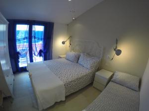 马达莱纳博尔戈普塔别墅旅馆的卧室配有白色的床和窗户。