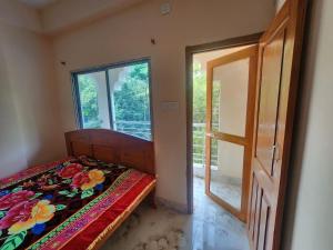 mayapurRadha Gopikanta Guest House - a family Homestay near Iskcon Mayapur的一间卧室设有床、窗户和门