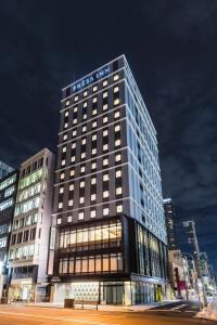 大阪Sotetsu Fresa Inn Yodoyabashi的一座高大的建筑,上面有标志