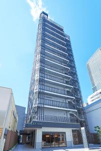 神户Sotetsu Fresa Inn Kobe Sannomiya的一座高大的建筑,有很多窗户