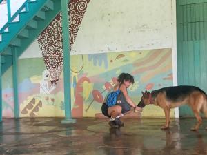 BalgueFinca Magdalena Eco Lodge的一只小女孩在壁画前抚摸狗