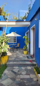 阿雷基帕COLONIAL SAN LAZARO的蓝色的建筑,设有配有桌子和遮阳伞的庭院