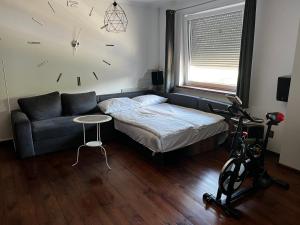 亚罗钦Studio na MIARĘ的一间卧室配有一张床、一张沙发和一个时钟