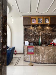 塞卡凯فندق الحنوة的大堂设有前台和一张带照片的墙壁