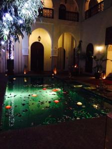 马拉喀什雷亚德夏玛套房酒店及Spa的建筑物里一个灯光游泳池