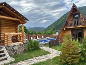 博尔若米Eco House Borjomi的小木屋设有游泳池和房屋