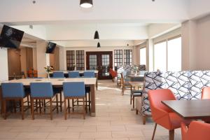北锡拉丘兹雪城机场智选假日酒店的一间带桌椅的用餐室