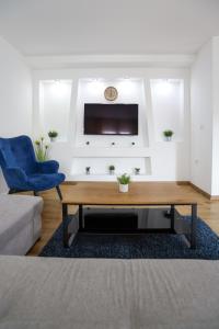 SurčinAirport Stay Apartments的客厅配有咖啡桌和蓝椅