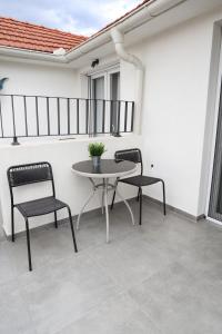 SurčinAirport Stay Apartments的阳台的天井配有2把椅子和1张桌子