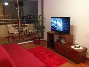 维纳德马Apartamento Castilla的客厅配有红色沙发和平面电视
