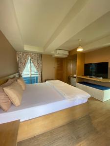 华欣Huahin Place Guest House的卧室配有一张白色大床和电视。