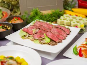 嬬恋村万座高原酒店 的餐桌上摆放着盘子,有肉和沙拉