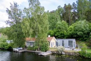 斯德哥尔摩Beautiful luxury family home surrounded by nature and water and only 20 minutes from city center的水边的房子,里面装有小船