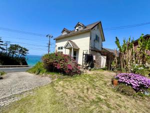 京丹后市レンタルコテージサントロペ的路边花的白色房子