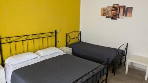 菲乌米奇诺盆景住宿加早餐旅馆的黄色墙壁客房的两张床