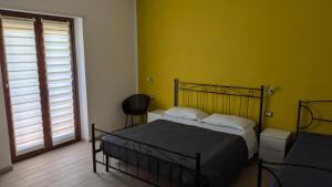 菲乌米奇诺盆景住宿加早餐旅馆的一间卧室设有一张床和黄色的墙壁