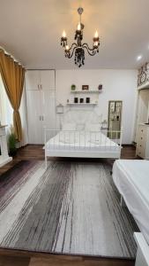 锡比乌Piazza Grande Apartment的一间大卧室,配有一张白色的床和吊灯