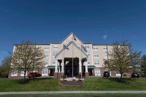 哈里斯堡Country Inn & Suites by Radisson, Harrisburg - Hershey West, PA的一座大建筑,前面有一个钟