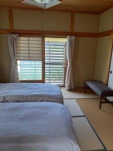 直岛町Kagawagun - House - Vacation STAY 01716v的一间卧室设有两张床和窗户。