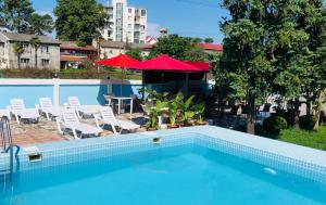 乌雷基Hotel Mirage Ureki的一个带椅子、桌子和遮阳伞的游泳池