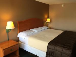 圣罗伯圣罗伯特经济酒店 的一张位于酒店客房的床位,配有两盏灯