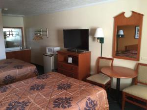 圣罗伯圣罗伯特经济酒店 的一间酒店客房,配有一张床、一台电视和一张桌子