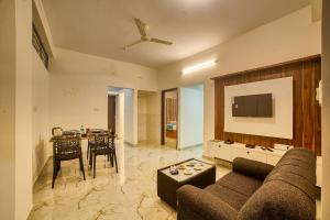 班加罗尔Hotel Airport Southgate Bangalore的客厅配有沙发和桌子