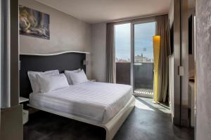 罗马贝斯特韦斯特皇家圣缇纳大酒店的一间卧室设有一张床和一个大窗户