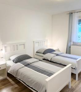 杜伊斯堡2-Schlafzimmer-Wohnung mit Parkplatz-Balkon-Küche- Garten, Nahe DUS Airport, Messe的一间卧室设有两张床和窗户。