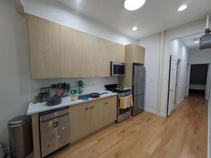 纽约51-1A Renovated 3br 2bath Prime soho的厨房配有木制橱柜和炉灶烤箱。