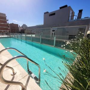 布宜诺斯艾利斯Arevalo 2700 - Las Cañitas的一座游泳池,旁边是一座建筑物,上面有金属扶手