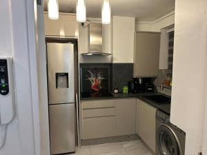伦敦Remarkable 1-Bed Apartment in London的厨房配有不锈钢冰箱和洗碗机