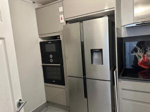 伦敦Remarkable 1-Bed Apartment in London的厨房配有不锈钢冰箱和电器