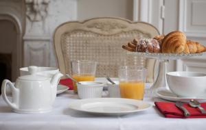 特鲁瓦M特鲁瓦住宿加早餐旅馆的一张桌子,早餐包括羊角面包和橙汁