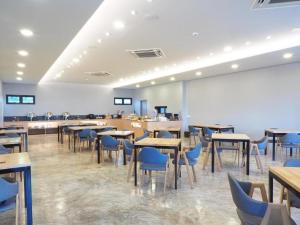 拉差汶里Sans Hotel的一间配备有桌子和蓝色椅子的用餐室