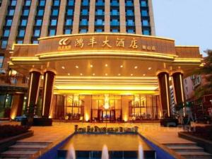 深圳Hongfeng Hotel Nanshan Branch的一座大型建筑,前面有一个喷泉