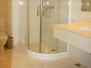 北京Beijing Ruyi Business Hotel的一间带玻璃淋浴和水槽的浴室