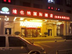 上海Vienna International Hotel Shanghai Hongqiao Expo Center Caohejing的夜间停在大楼前的汽车