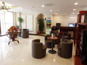 北京GreenTree Inn Beijing Capital Airport New International Exhibition Center Express Hotel的大堂内带椅子和桌子的等候室