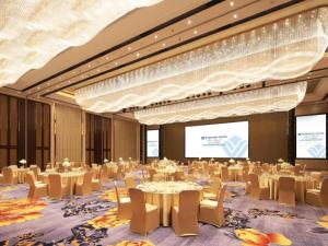 重庆Wyndham Grand Plaza Royale Huayu Chongqing的一间会议室,配有桌椅和投影屏幕